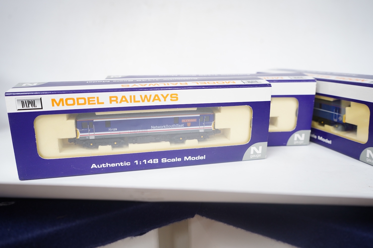 Three boxed Dapol N gauge railway Class 73 electro-diesel locomotives; 73119 Kentish Mercury (ND-022a), 73129 City of Winchester (ND-012a) and 73133 (ND-021b). Condition - good.